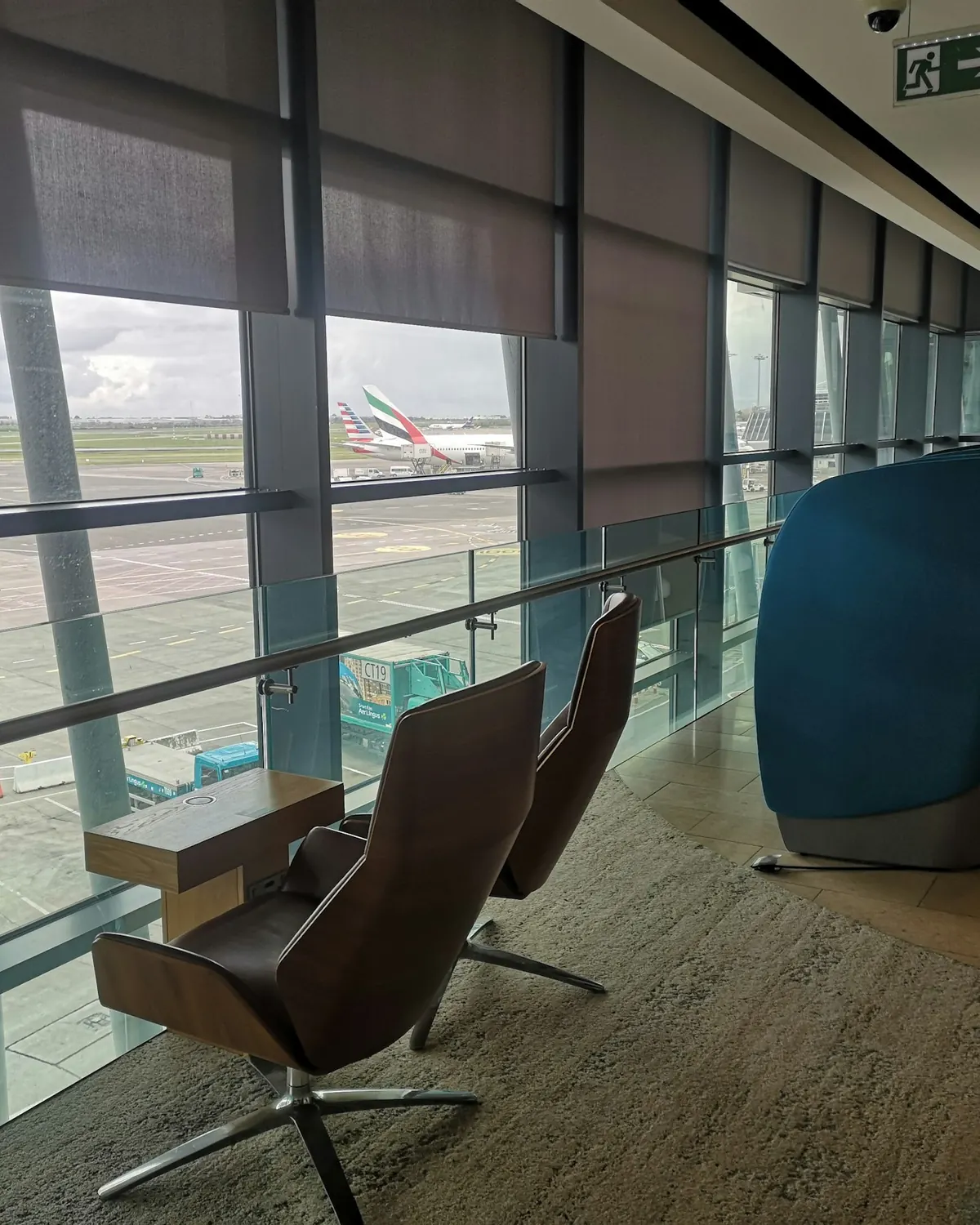Quiet airport lounge with leather armchairs and windows onto the apron